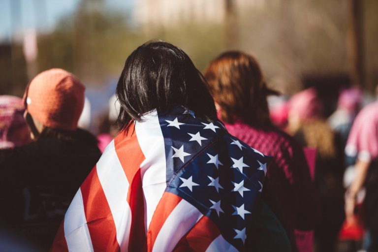 Image of a woman wearing the American flag on her back. Zach Roberson Immigration attorney. Staff Page.