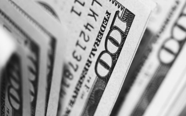 Closeup image of 100 dollar bills in black and white