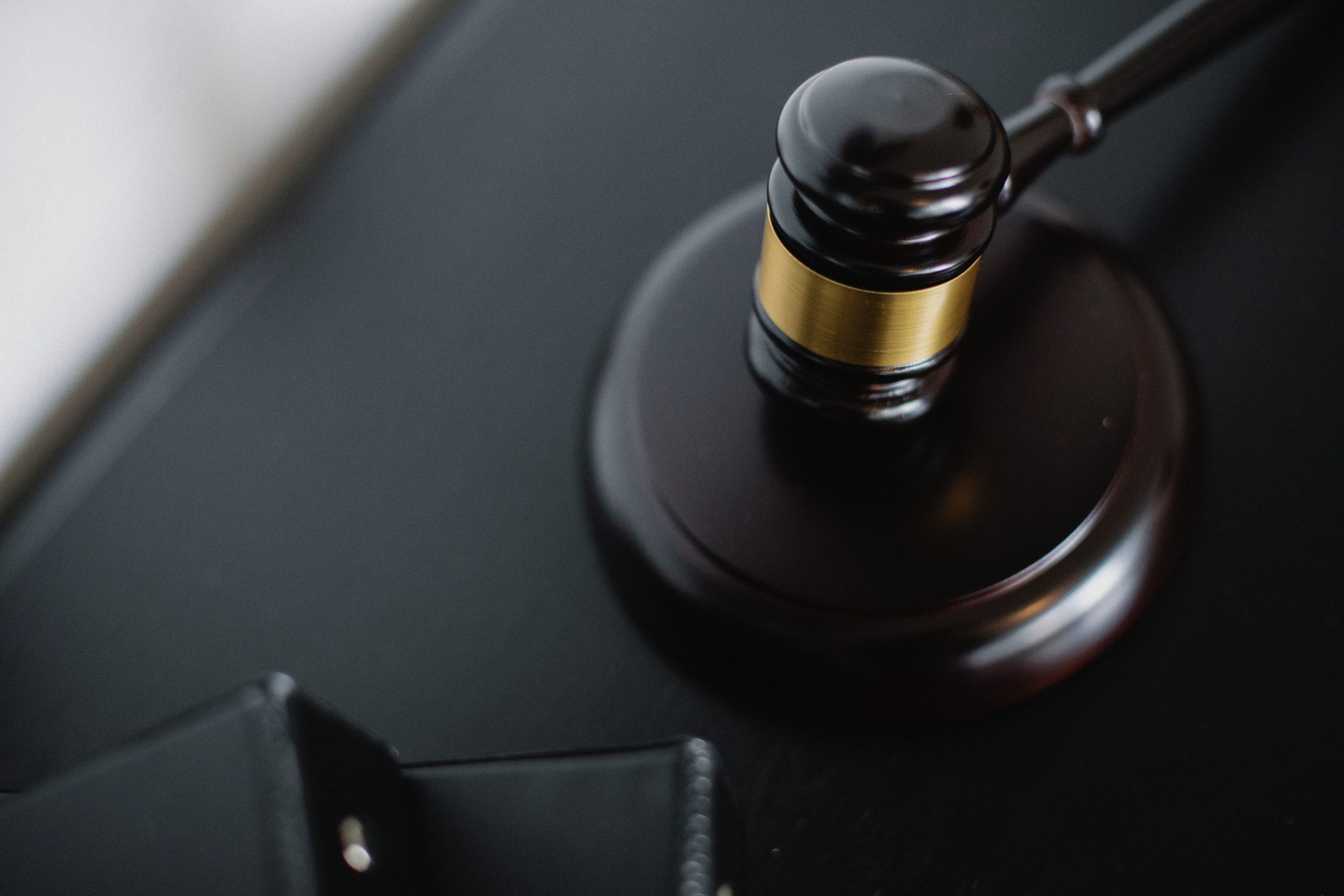 Image of a black judge's gavel on a black desk