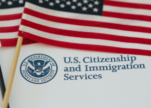 Image of a USCIS document up close with an American Flag, Immigration.