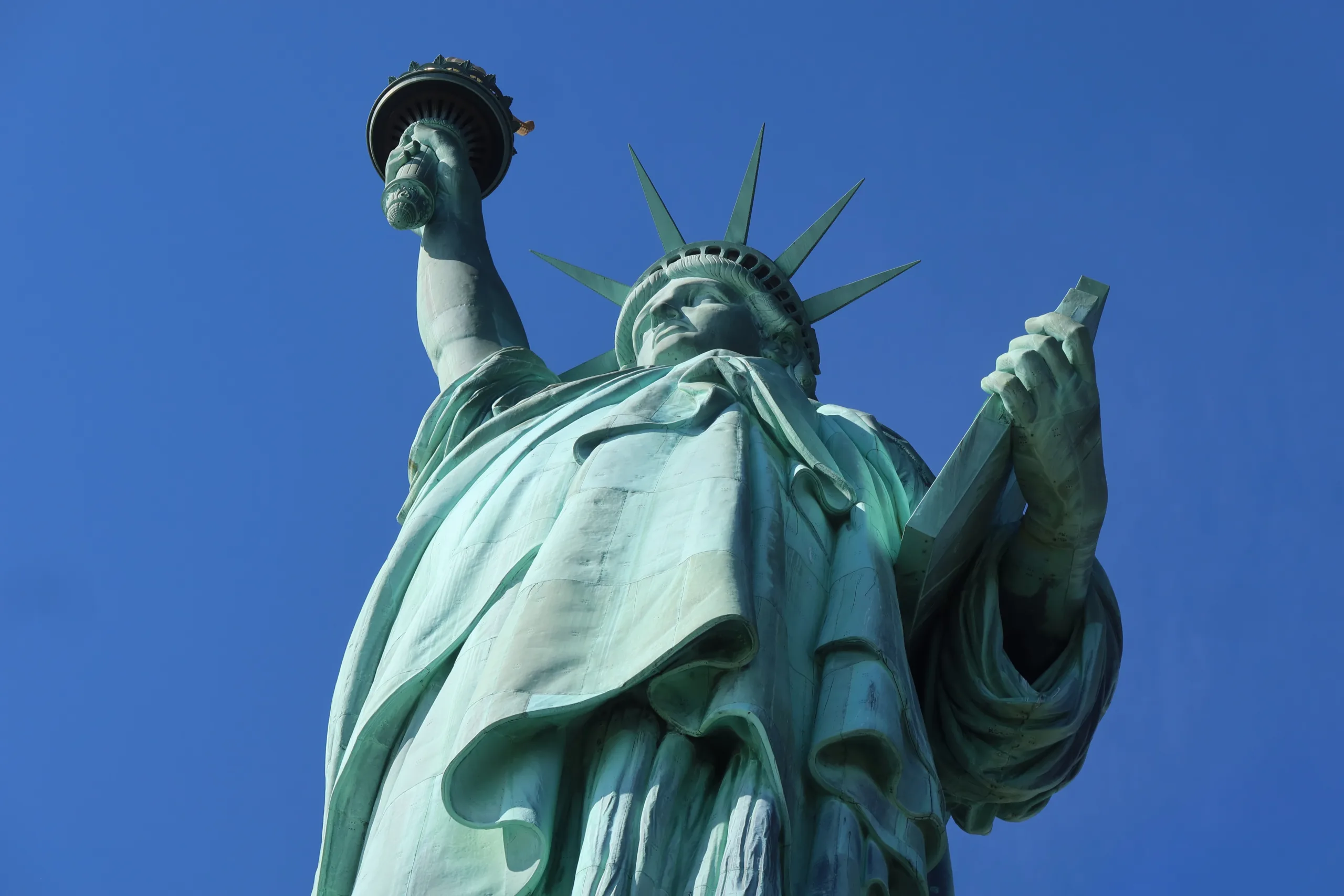 Image of the Statue of Liberty against a blue sky, shot from below. Citizenship and Immigration attorney.