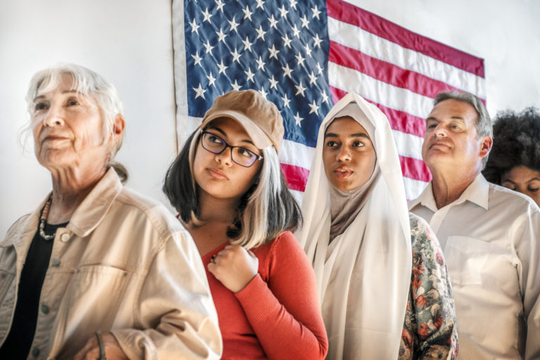 Image of people lined up in front of the American Flag to represent Asylum to the US