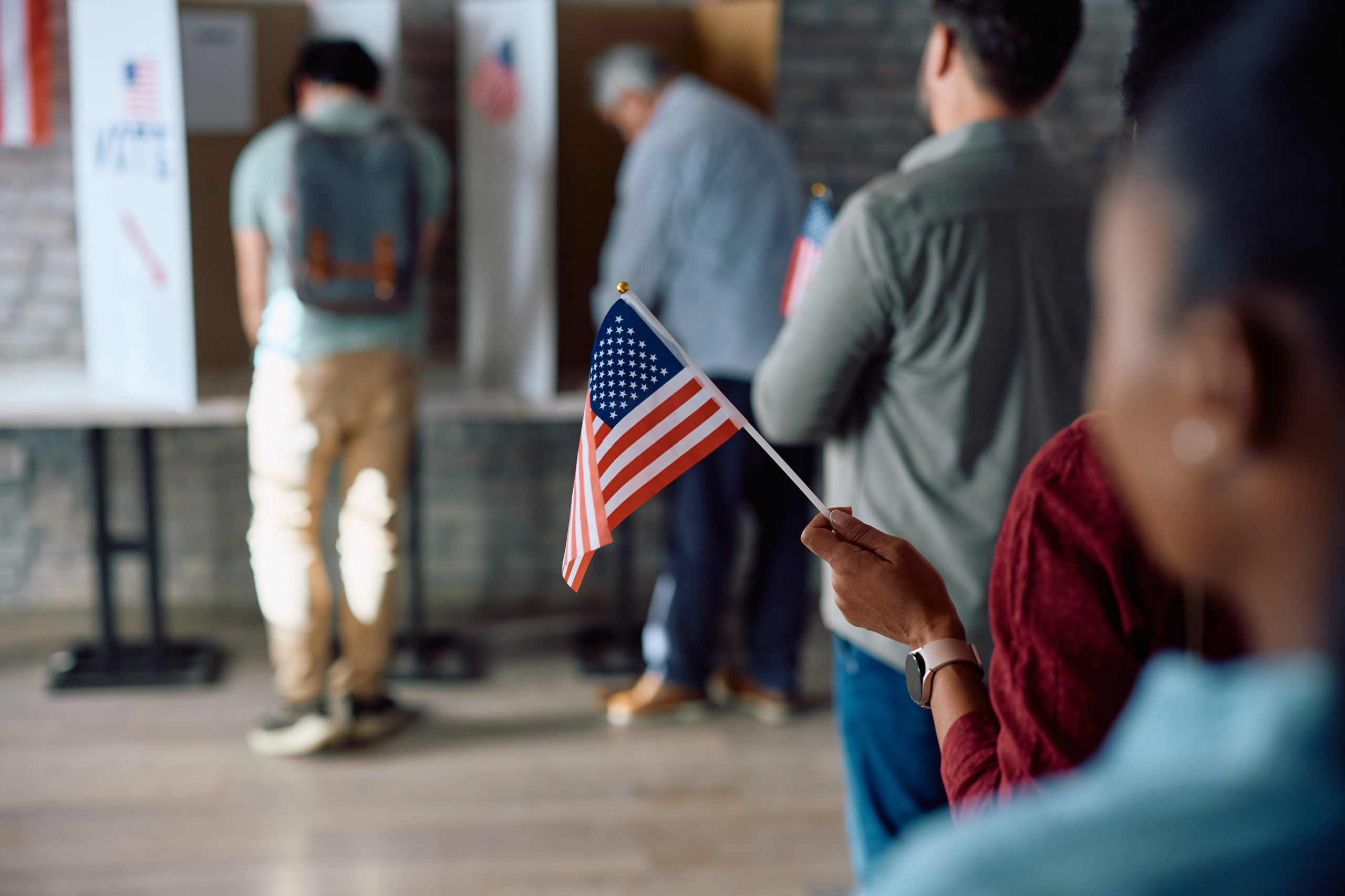 Image for Visa application process. Image of a line for immigration services and a person holding an American falg.