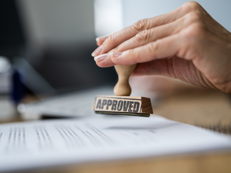 Image of work permit being stamped for approval by hand