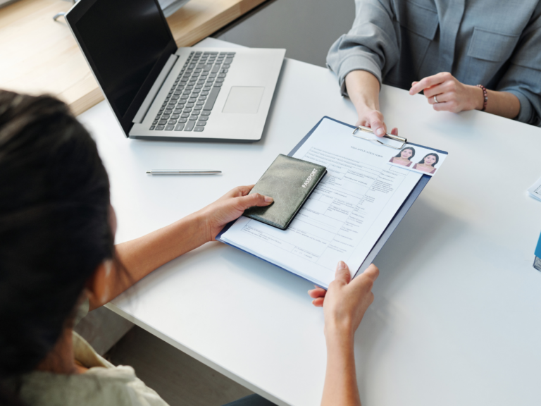 Board of immigration appeals representation - image of a woman handing over passport and documentation to person behind desk.